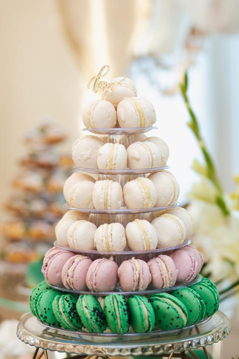 Wedding pastries on a mirror tray. Candy bar. Buffet with macaroons delicacies