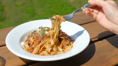 A woman eating pasta outdoors. Fettuccine, Terrace Seating, Infection Control