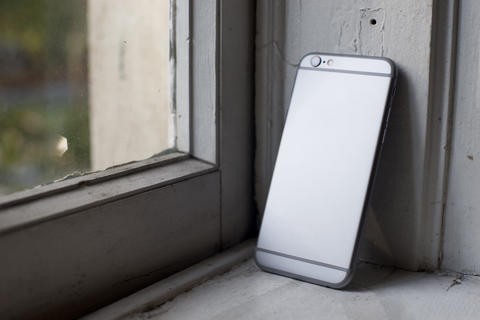 Silver smartphone on gray background