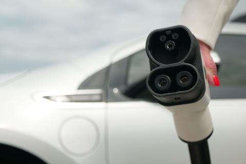 Hand holds plug EV