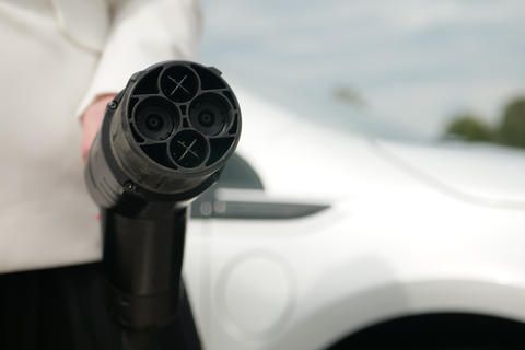 Hand holds plug EV