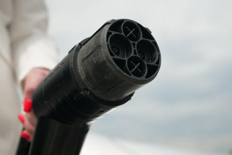 Hand holds plug EV