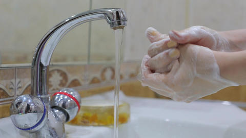 Coronavirus pandemic prevention wash hands with soap warm water rubbing fingers