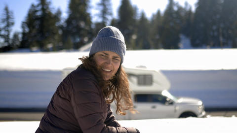 Thoughtful Woman with pine trees and snow as background at Crater Lake, Oregon