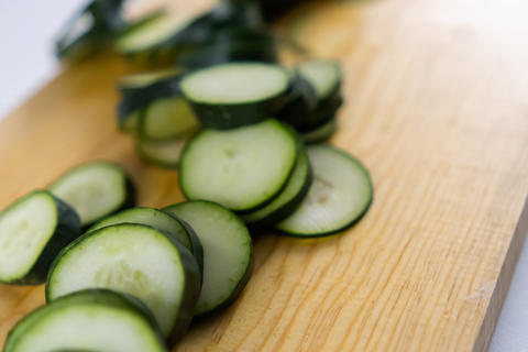 Fresh sliced cucumber on a wooden cutting board