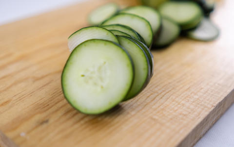 Fresh sliced cucumber on a wooden cutting board