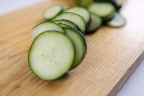 Fresh sliced cucumber on a wooden cutting board