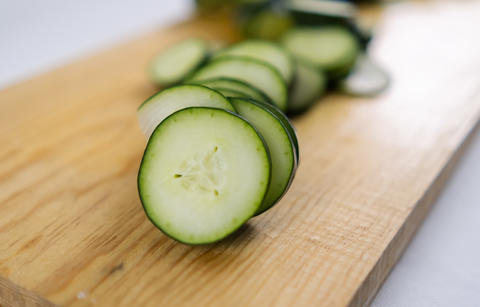 Fresh sliced cucumber on a wooden cutting board