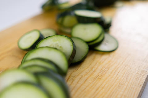 Fresh sliced cucumber on a wooden cutting board