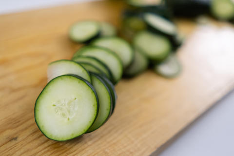 Fresh sliced cucumber on a wooden cutting board