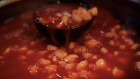 Ladle stirring delicious traditional Mexican pozole in cooking pot