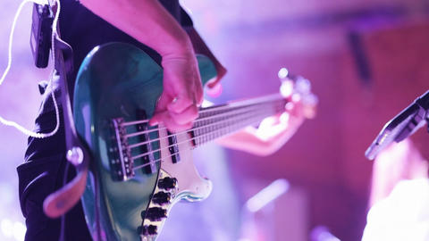 Musician playing the guitar during a live performance. Strumming electric guitar