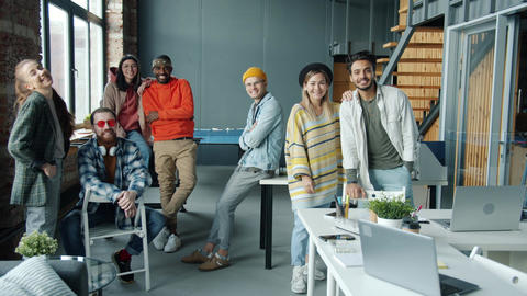 Diverse group of employees smiling and laughing indoors in modern coworking