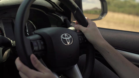 Driving Toyota SUV car. Man driver hands on steering wheel. Highway road