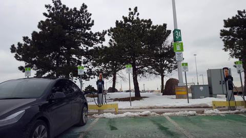 Driver Point of View Driving Up To EV Electric Vehicle Charging Station in Winter