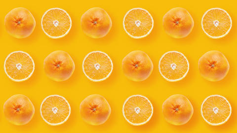 Many sliced oranges and many whole tangerines rotating on orange backgroundtop view 4k