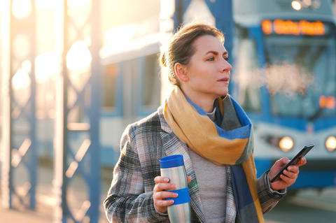 Portrait of a caucasian businesswoman in a coat, walking around the city on a