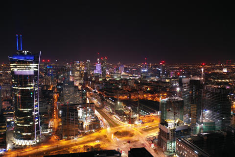 Aerial hyperlapse of Warsaw business center at night: skyscrapers and Palace of