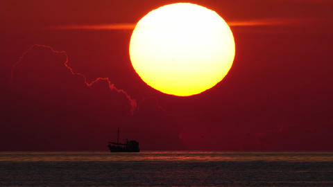 sun goes down with ship driving in foreground. telephoto lens real shot. part 2