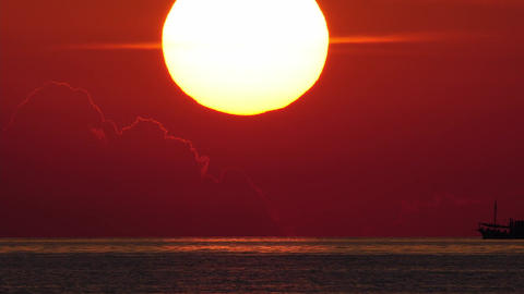 sun goes down with ship driving in foreground. telephoto lens real shot. part 1