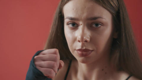 Pretty sportswoman looking at camera, stretching, boxing, kicking, working out