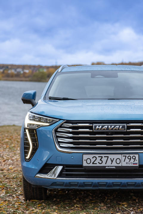 New blue color Haval Jolion at the edge of the river. All wheel drive suv at the nature