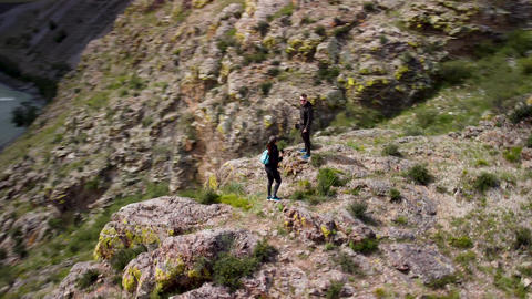 A couple of travelers walk through the hills