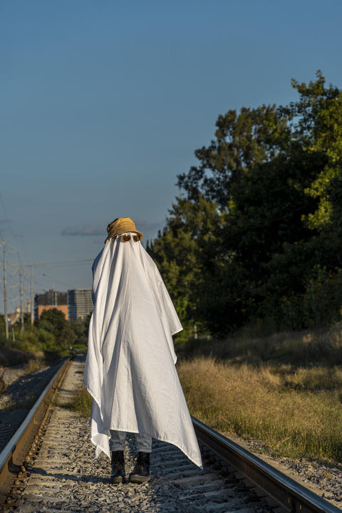 ghost on train tracks with train passing behind, at sunset, mexico latin america