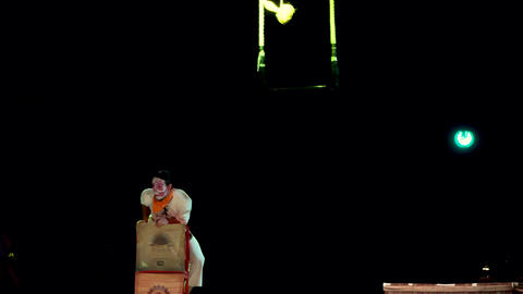 circus tightrope walker holding on to two ropes while doing a show climbing up