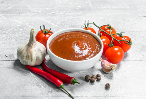Tomato sauce in bowl with chili pepper and garlic