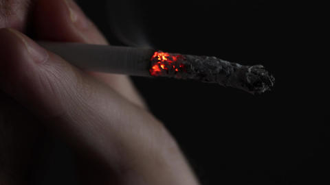 burning cigarette gif A burning cigarette in the hands of a smoker. nicotine addiction, smoke in
