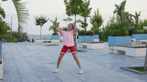 Athletic toddler kid jogger enjoy dancing in the park