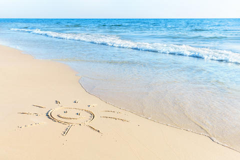 The drawing of the sun on sand beach with soft waves