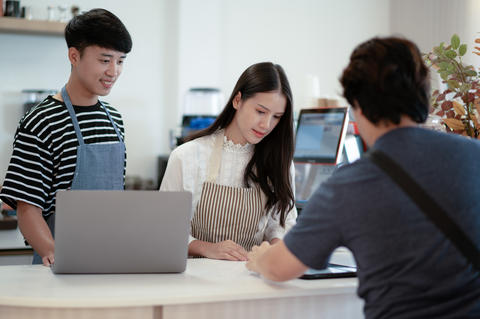 Young women and young men taking orders at the counter in a rest