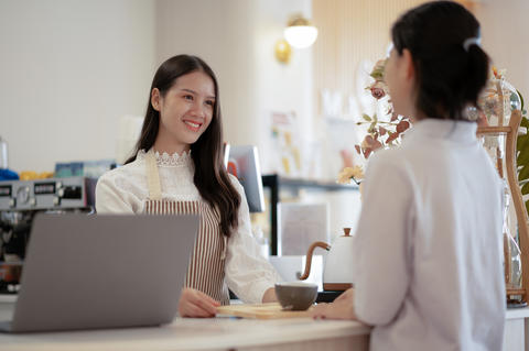 Young women and young men taking orders at the counter in a rest