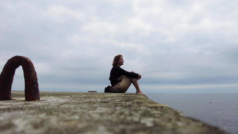 A young girl is sitting on the Black Sea coast. 0241 1