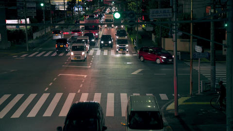 Cars, pedestrians, and bicycles passing along the road