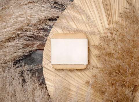 Soap bar with blank label on dried palm leaf near pampas grass t