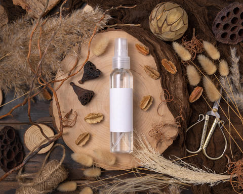 Cosmetic spray bottle on wood near natural boho decorations top