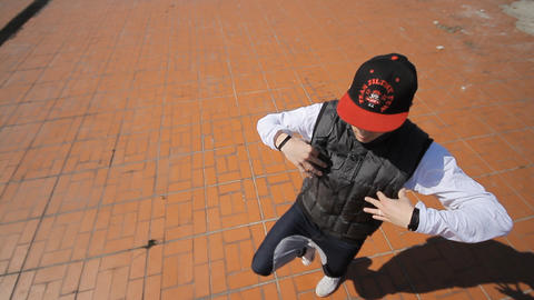 Hip-hop dancer in cap dances in the street of Sara
