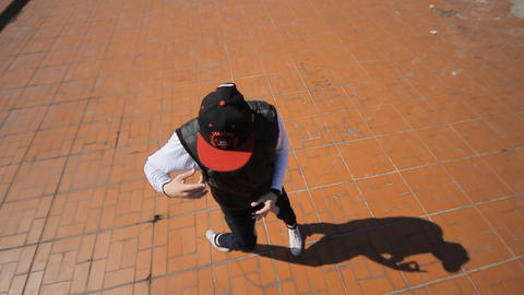 Hip-hop dancer in cap dances in the street of Sara