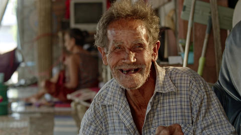 A smiling Asian man who is a poor elderly ragpicker or has a career collecting garbage and selling