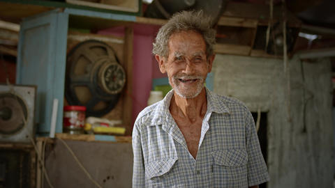 A smiling Asian man who is a poor elderly ragpicker or has a career collecting garbage