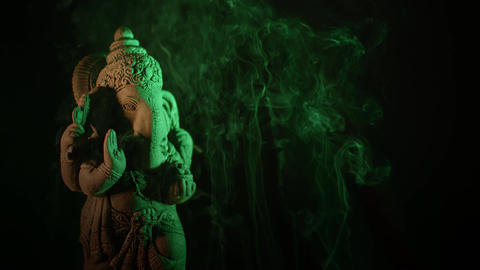Ganesha idol in giving boons made of sandstone on a black background at night