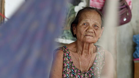 Asian woman who is a poor elderly ragpicker's wife , while swinging a cradle