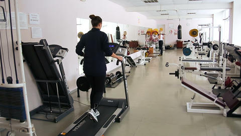 The girl running on the machine at the gym. Fitnes