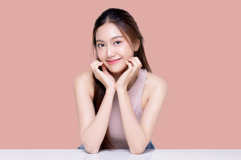Beautiful young Asian woman with healthy and perfect skin on isolated pink background