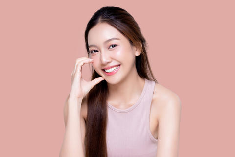 Beautiful young Asian woman with healthy and perfect skin on isolated pink background