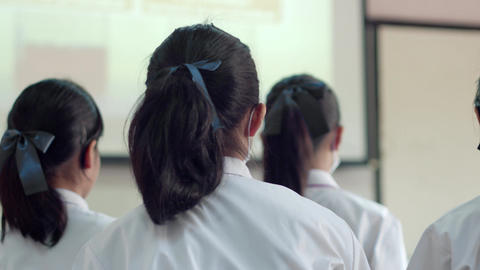 Asian high school students in white uniform actively study in science classroom