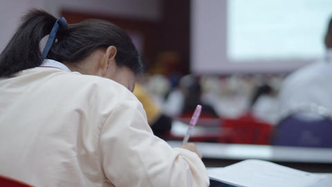 Asian female high school student is lecturing that a teacher teach on a big projector screen